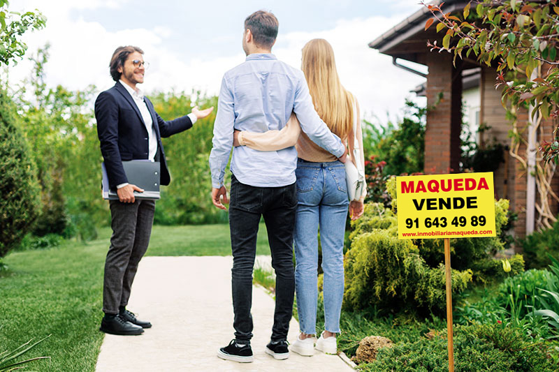 Fotografía de una joven pareja visitando una casa en venta con agente de Inmobiliaria Maqueda