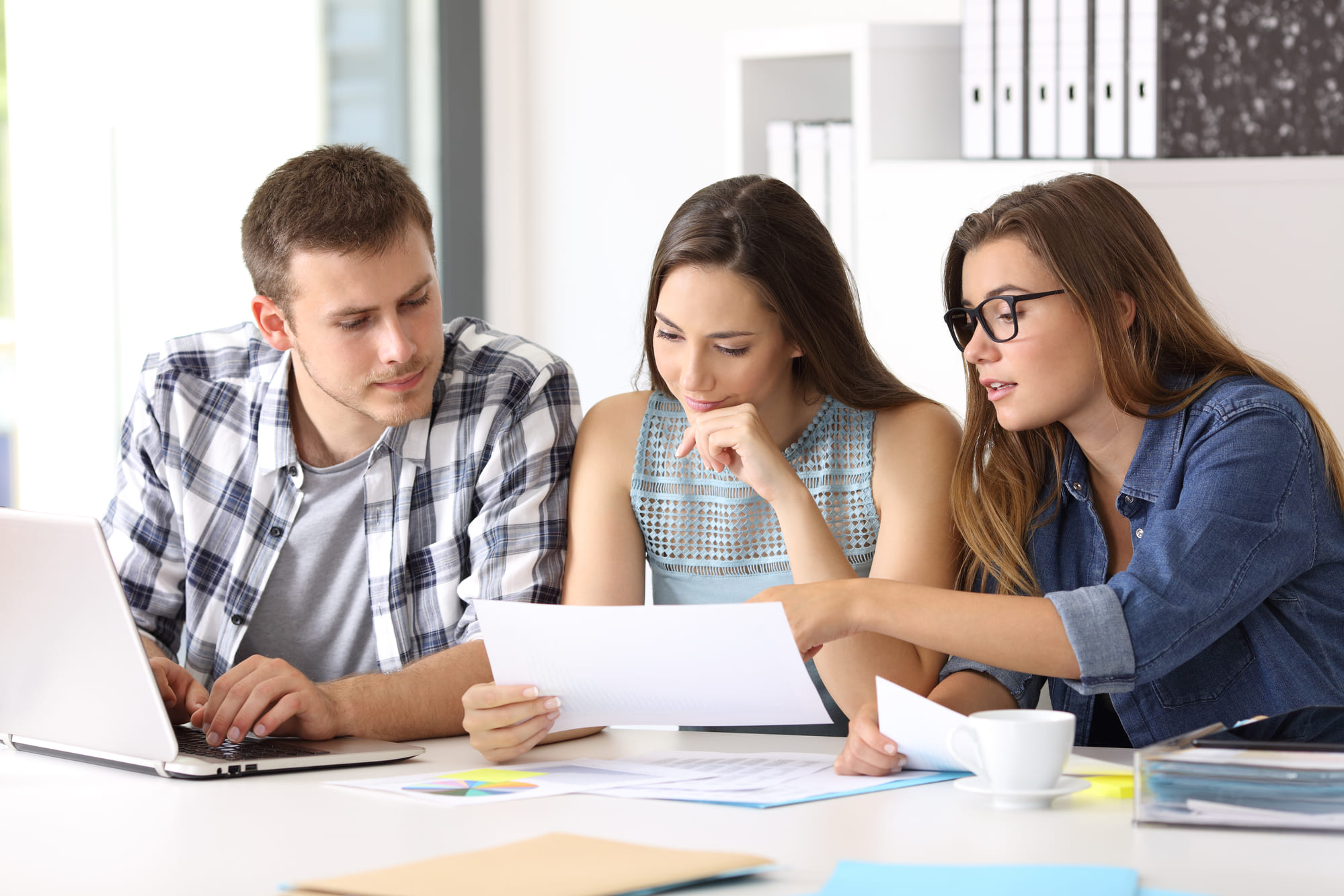 Fotografía de una joven pareja que es asesorada por un agente inmobiliario de Inmobiliaria Maqueda