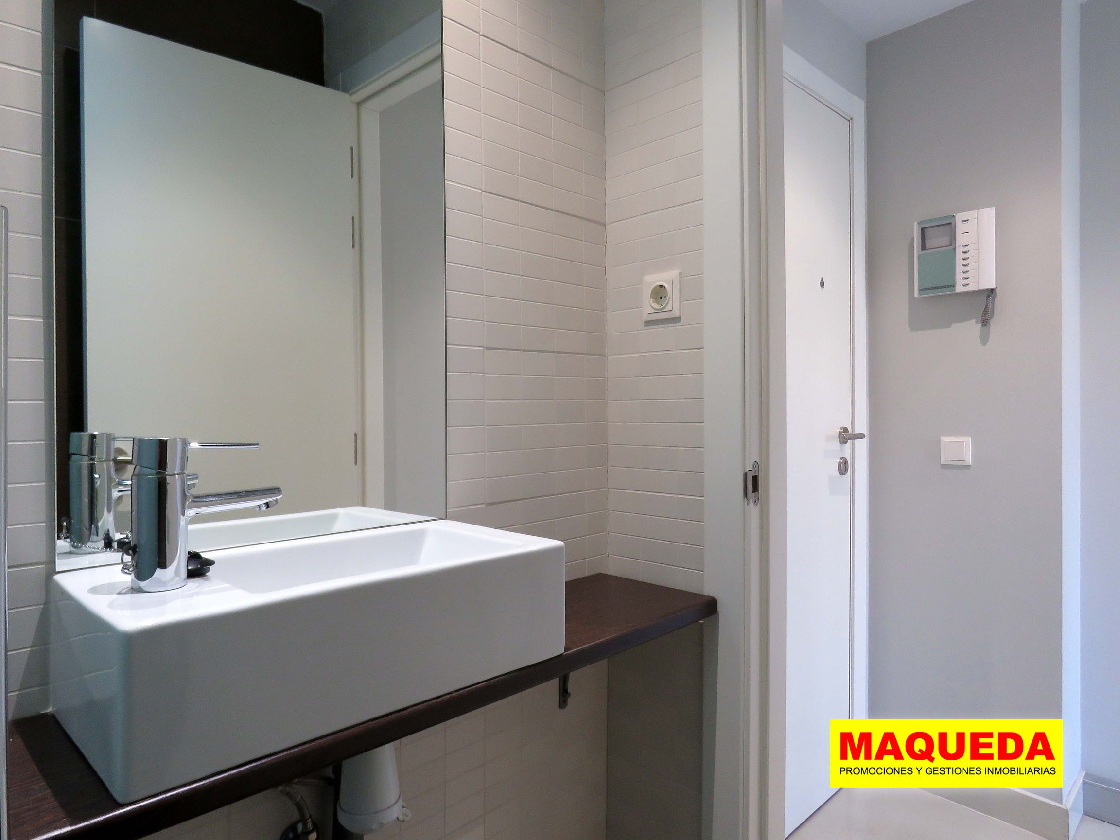 Primer plano del lavabo y espejo en el aseo de la planta baja