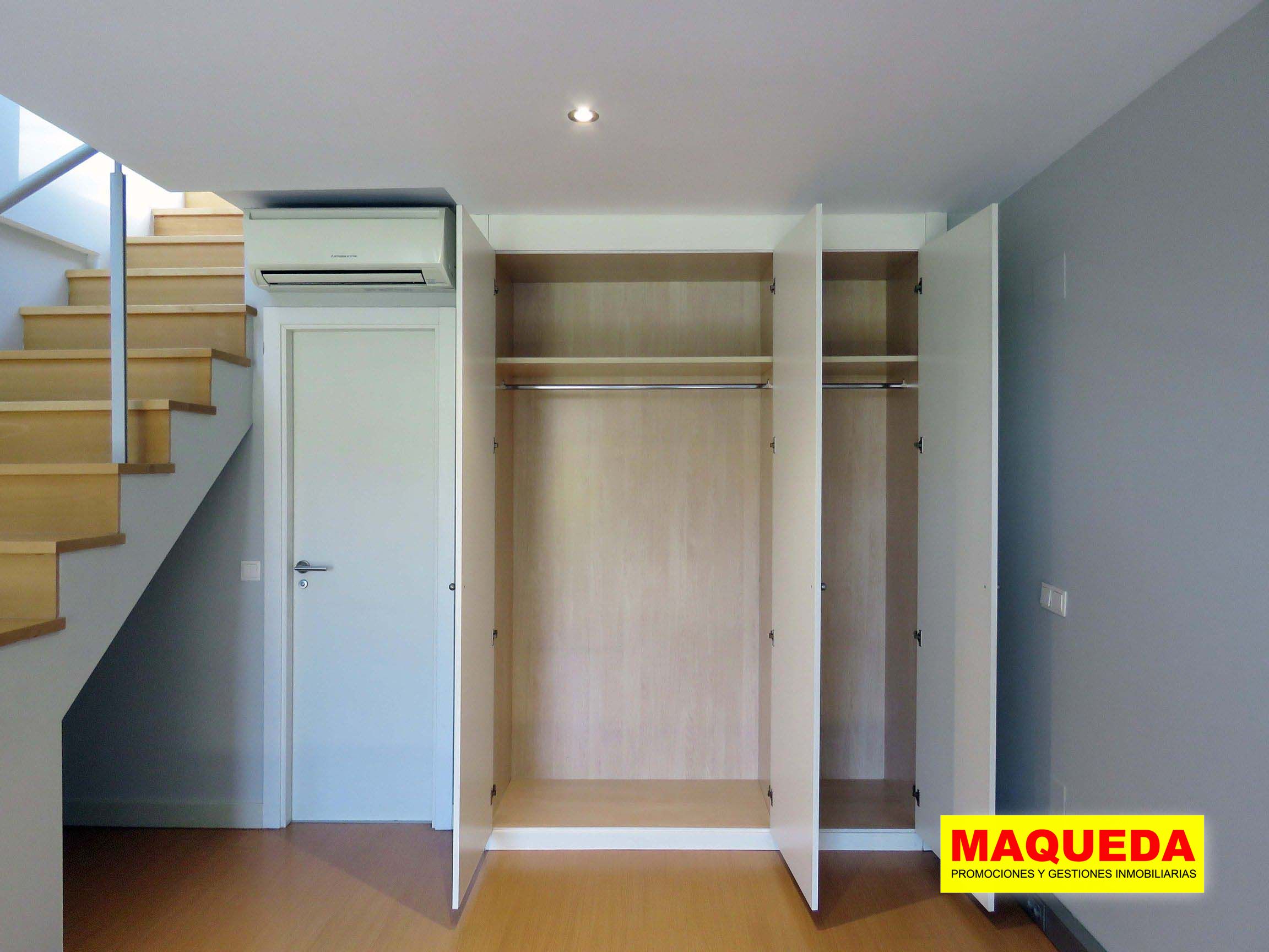 Detalle del armario empotrado con las puertas abiertas en la habitación