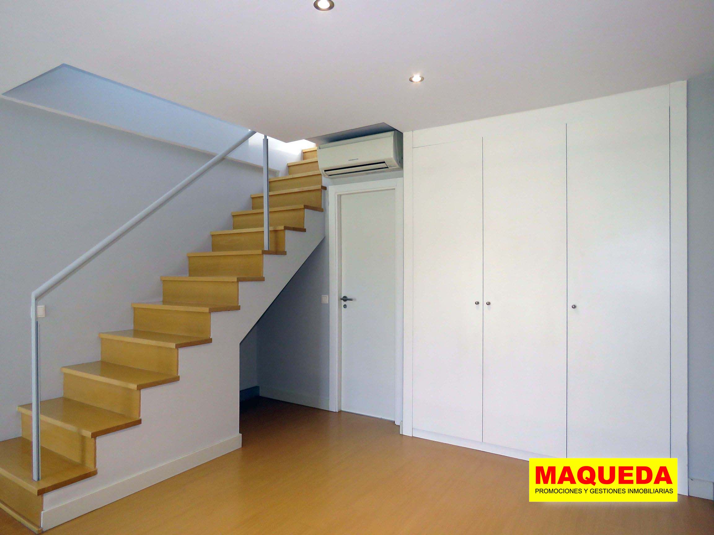 Habitación en planta alta con armario empotrado, aire acondicionado, puerta del baño y escalera de subida a la azotea