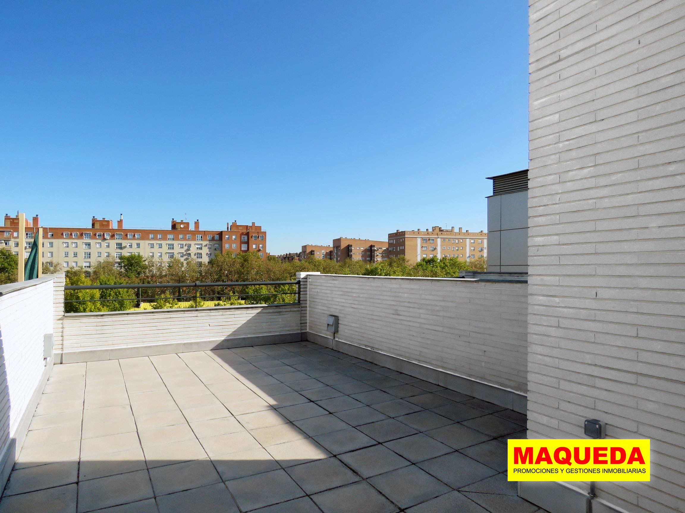 Terraza en la azotea con vistas a la pared de la derecha