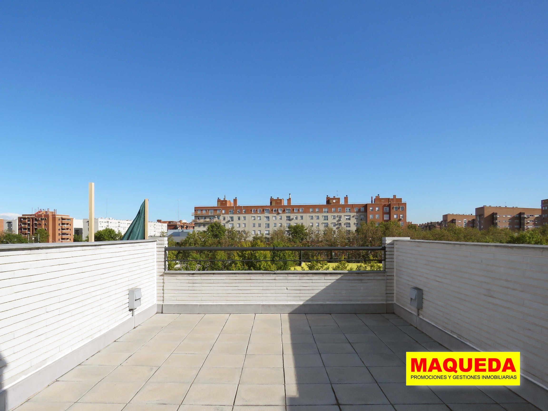 Terraza en la azotea con vistas abiertas al frente. Se aprecian los árboles en la avenida de Leganés y edificio de viviendas al fondo