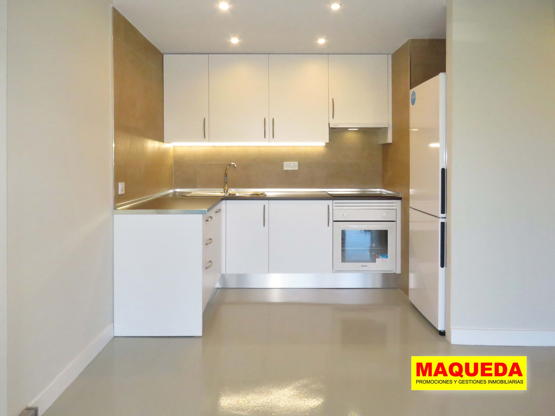 Cocina amueblada con iluminación bajo encimera, horno y frigorífico