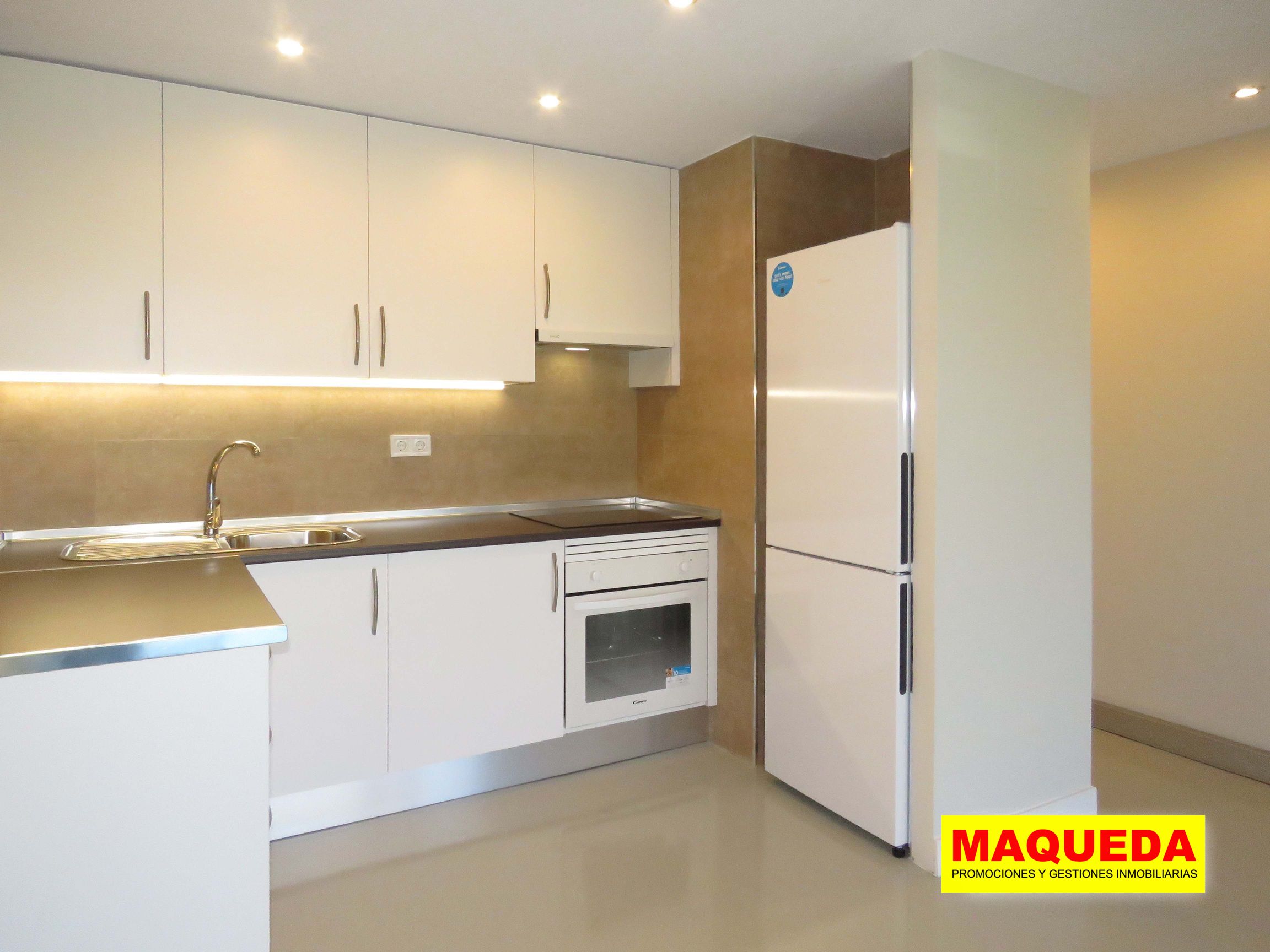 Cocina amueblada con iluminación bajo encimera, horno y frigorífico