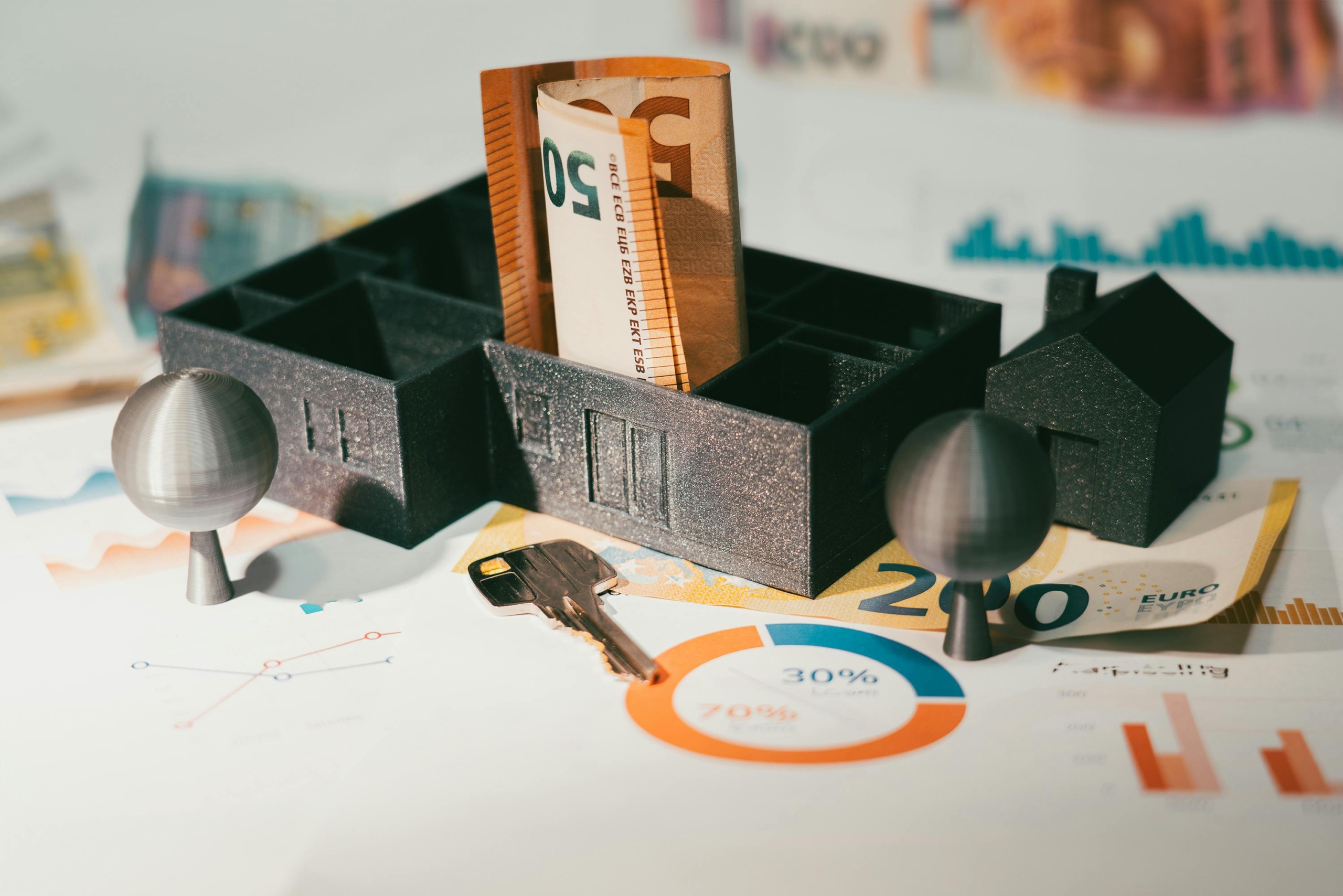 Sobre un documento de inversión, maqueta de una casa con billetes en el interior