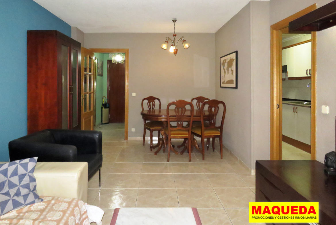 Salón con zona de comedor al fondo con mesa y sillas