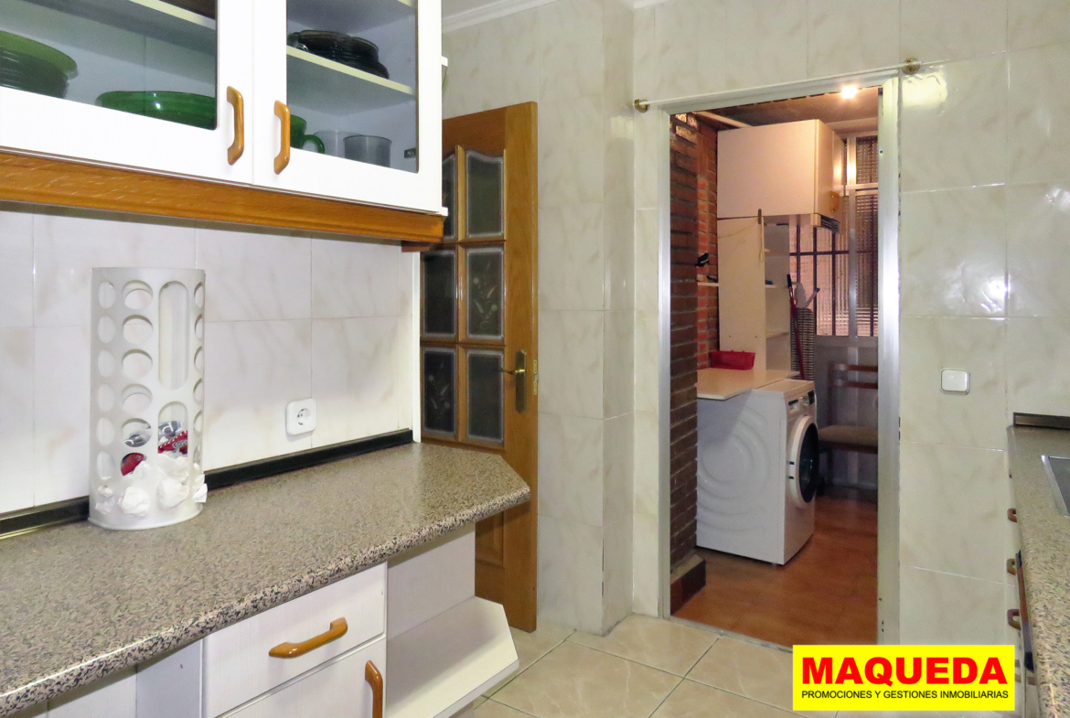 Cocina amueblada con tendedero acristalado al fondo