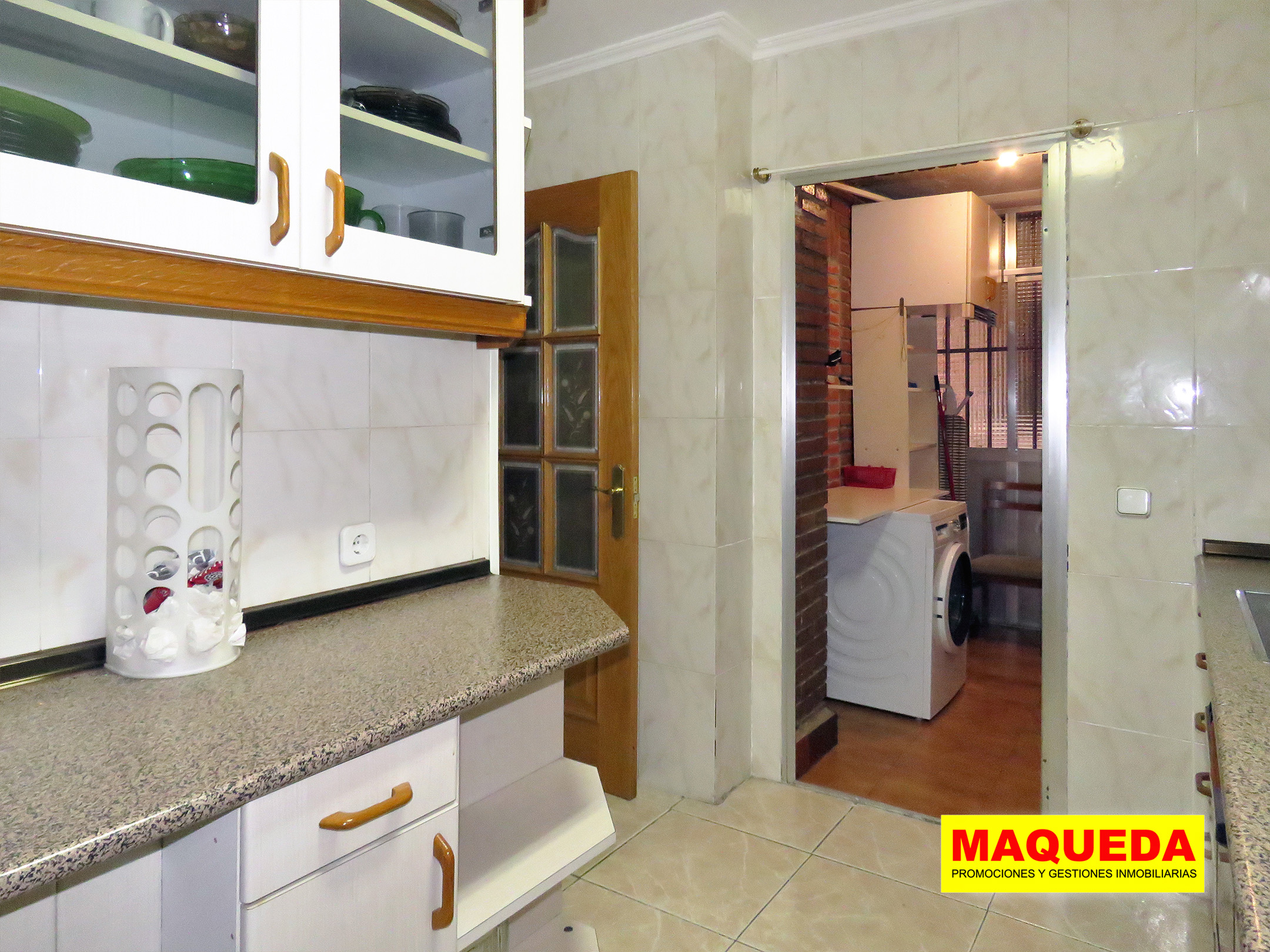 Cocina amueblada con tendedero acristalado al fondo