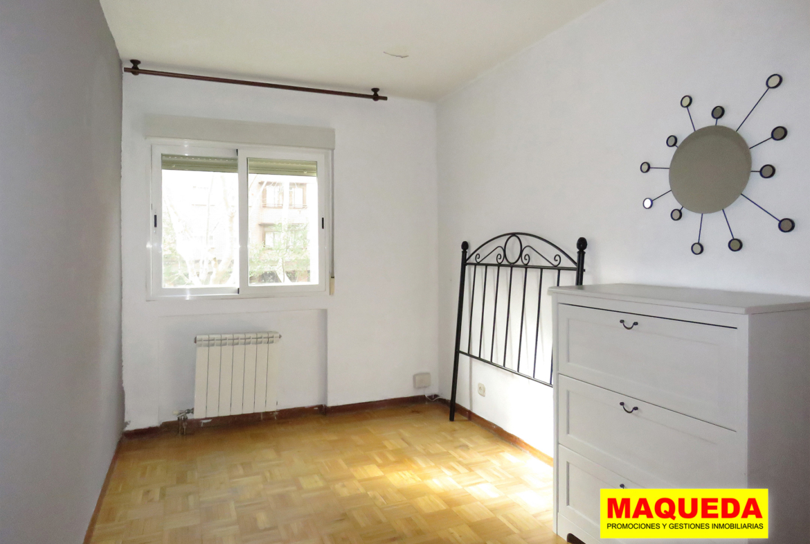 Dormitorio principal soleado con suelo de parquet