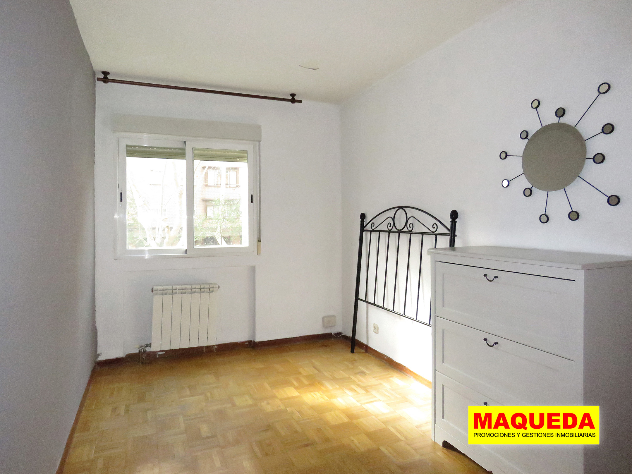 Dormitorio principal soleado con suelo de parquet