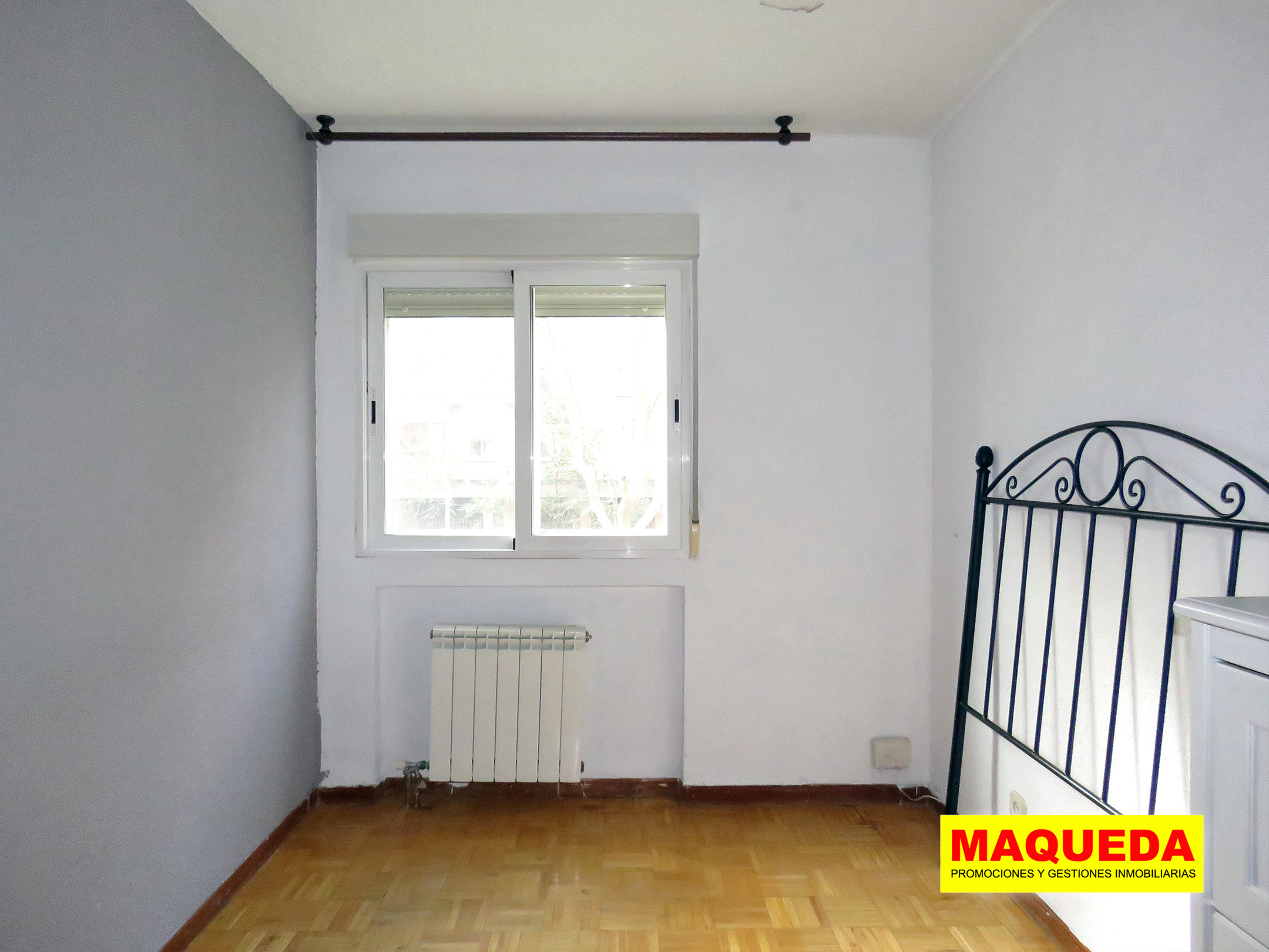 Dormitorio principal soleado con suelo de parquet