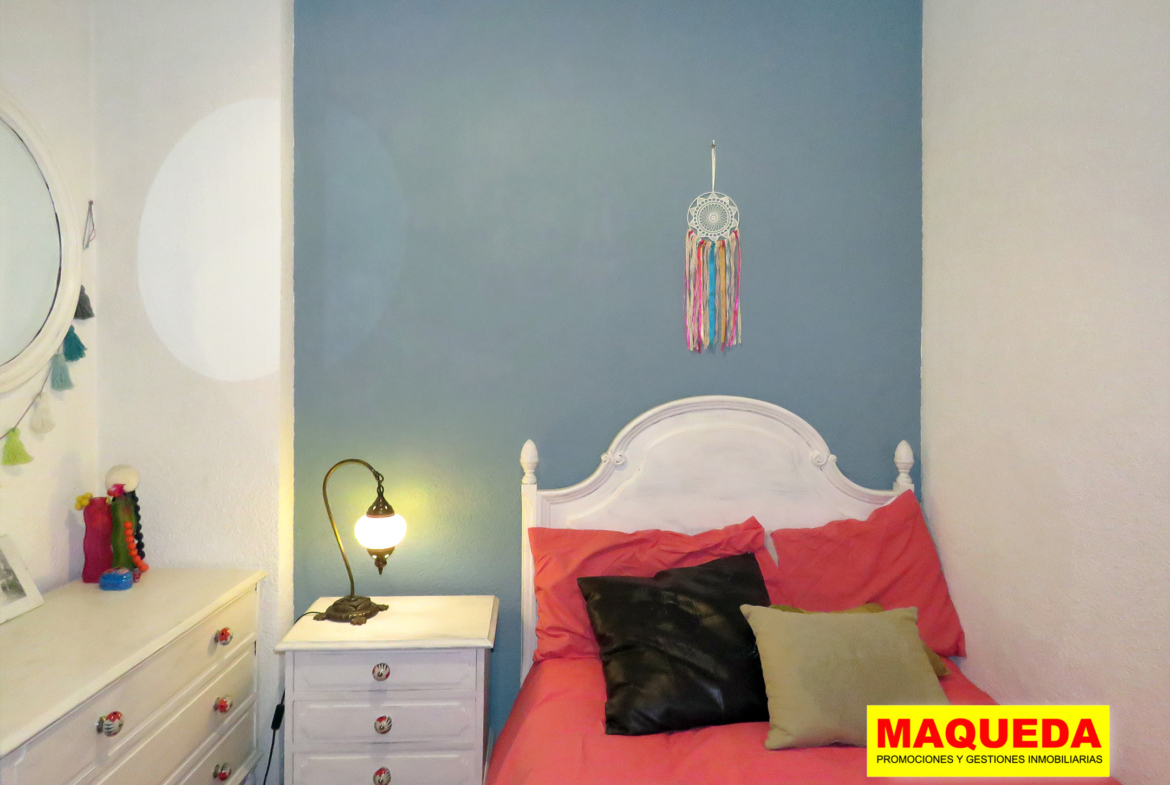 Dormitorio individual con cama y mesita de noche