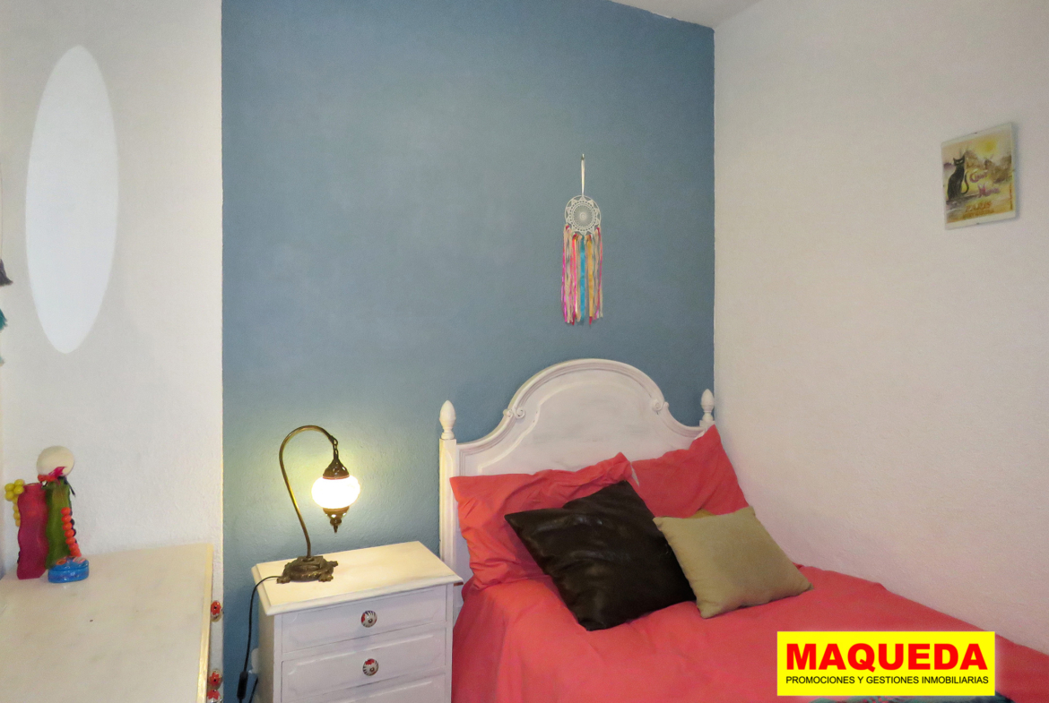 Dormitorio individual con cama y mesita de noche