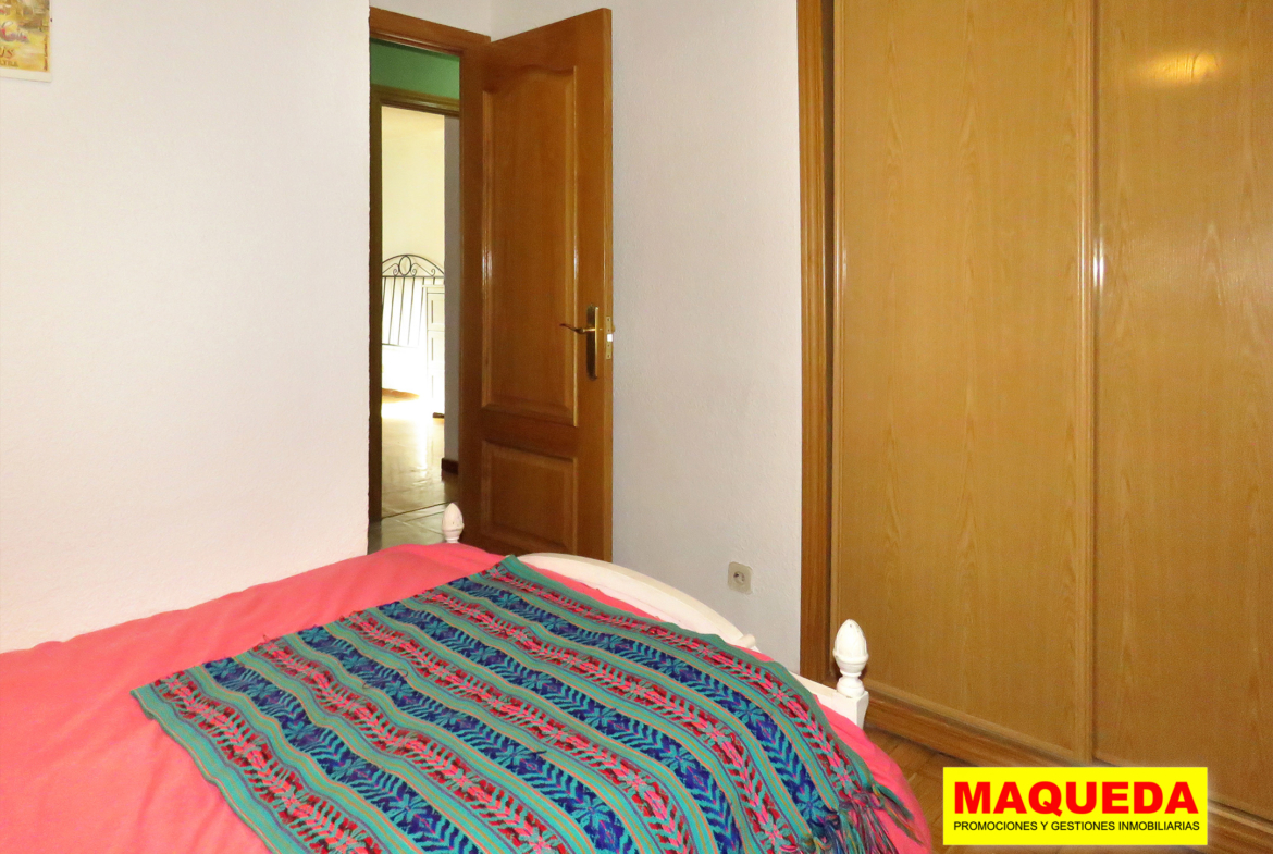 Dormitorio individual con armario empotrado y puerta de acceso al fondo