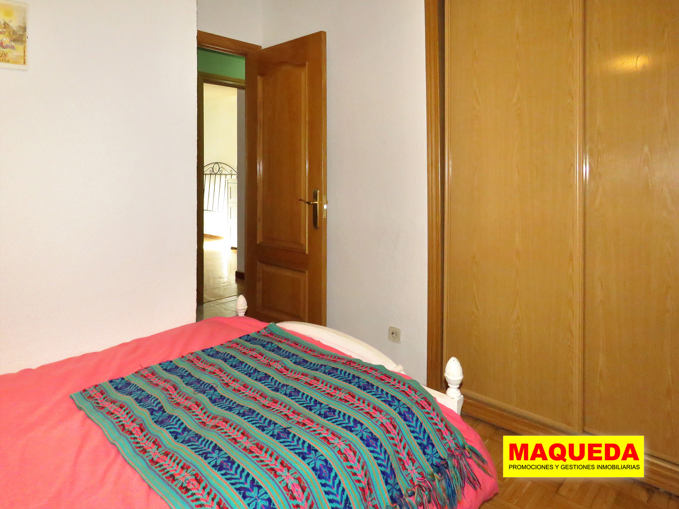 Dormitorio individual con armario empotrado y puerta de acceso al fondo