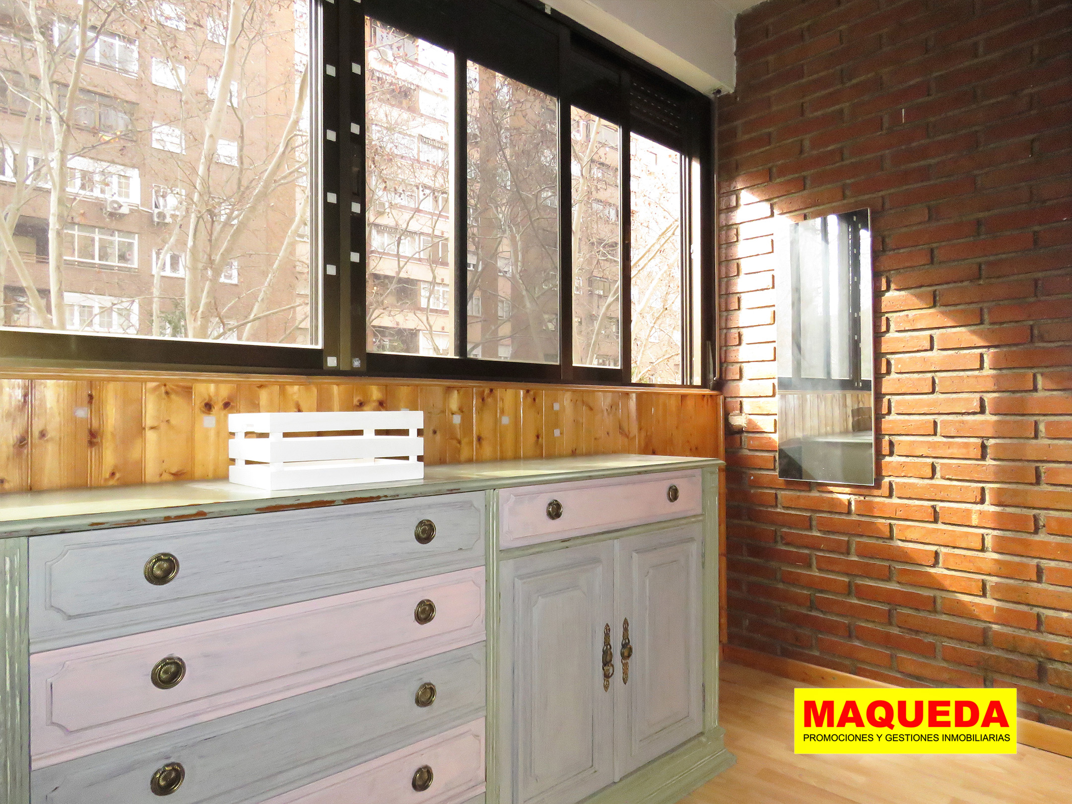 Terraza acristalada con pared de ladrillo visto y amplia cristalera