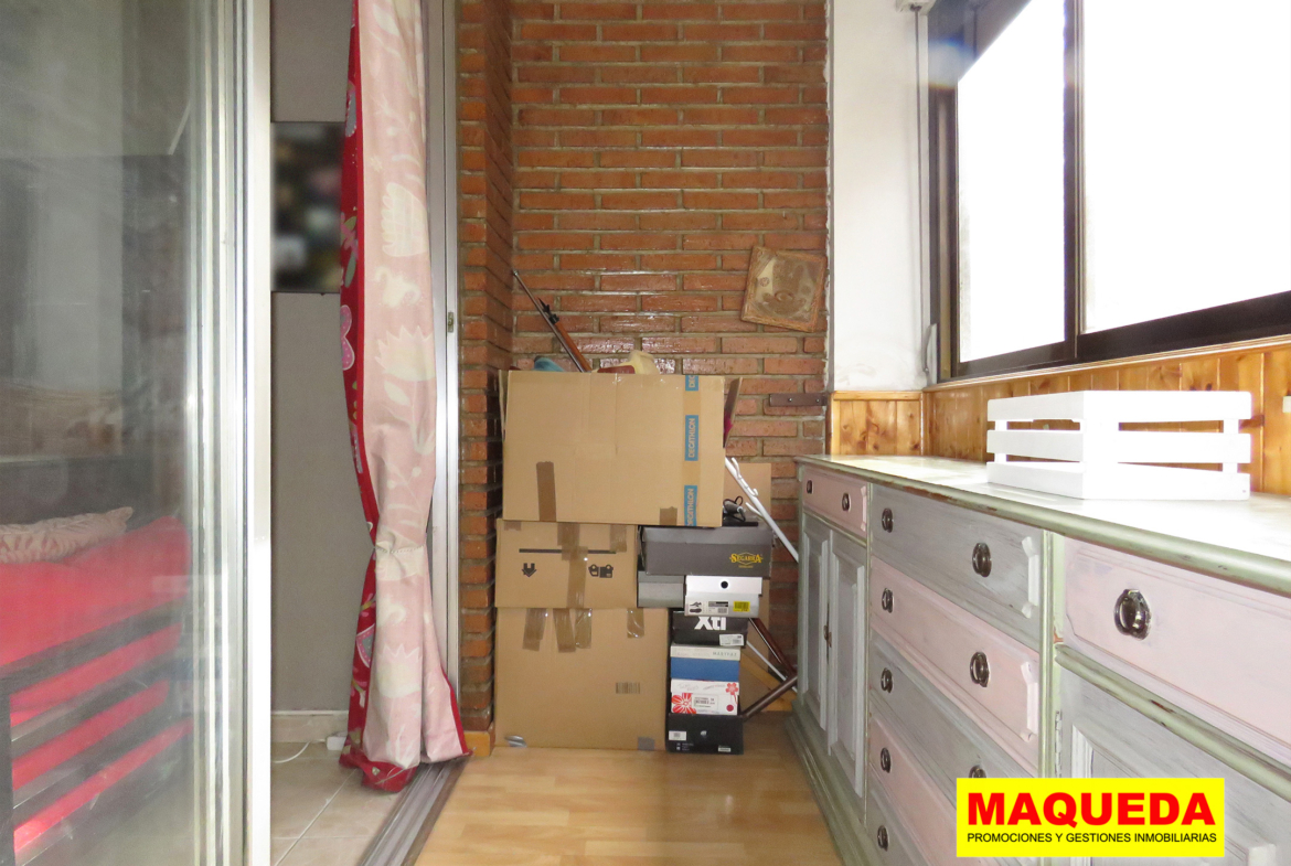 Terraza acristalada con pared de ladrillo visto y puerta corredera del salón