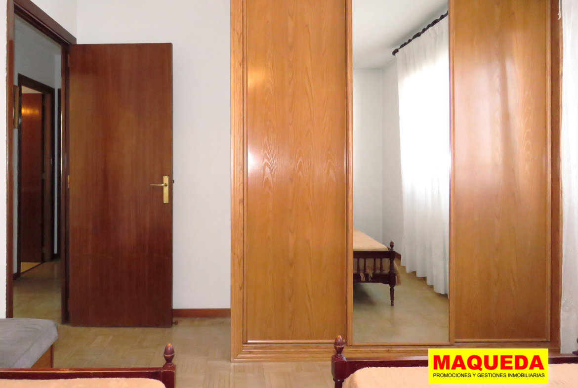 Dormitorio con dos camas y armario empotrado con espejo