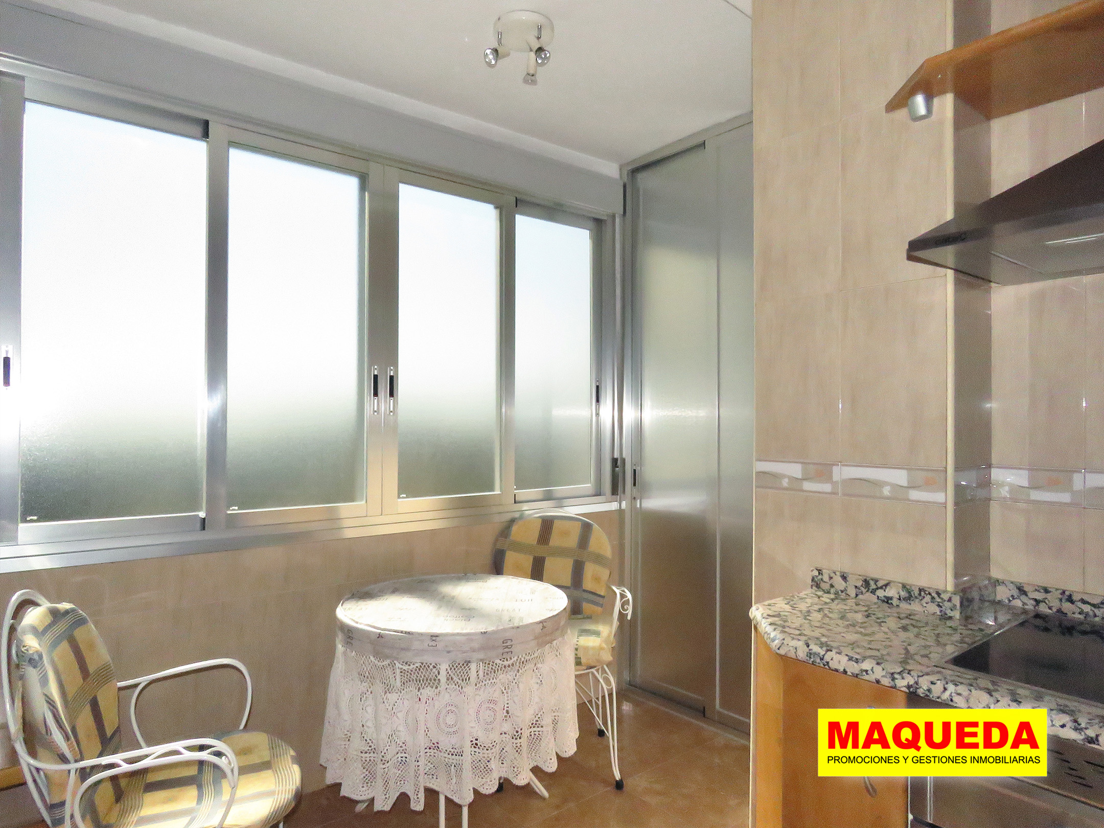 Zona de office en la cocina con armario de aluminio para despensa