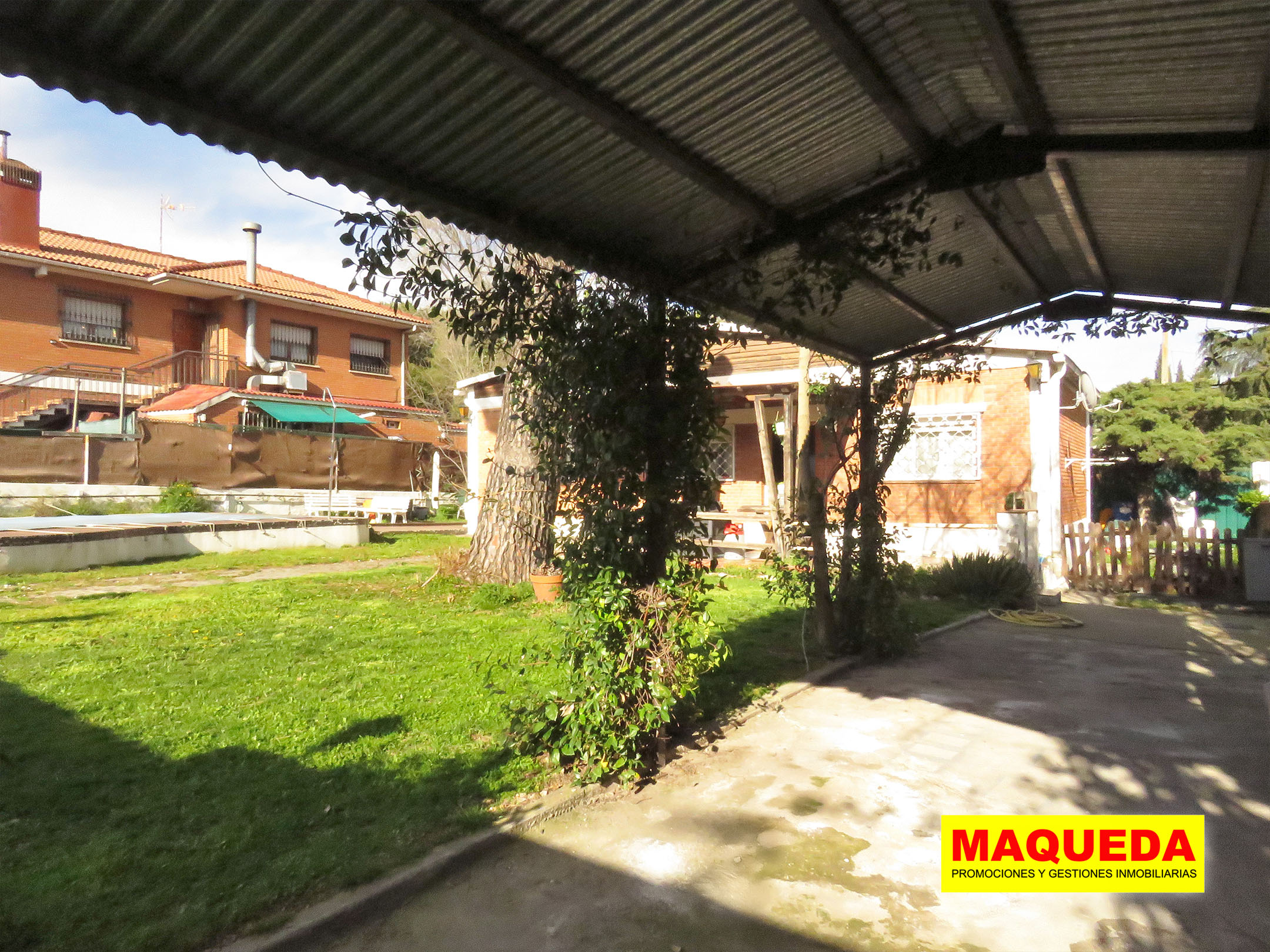 Zona de aparcamiento dell chalet con techado metálico