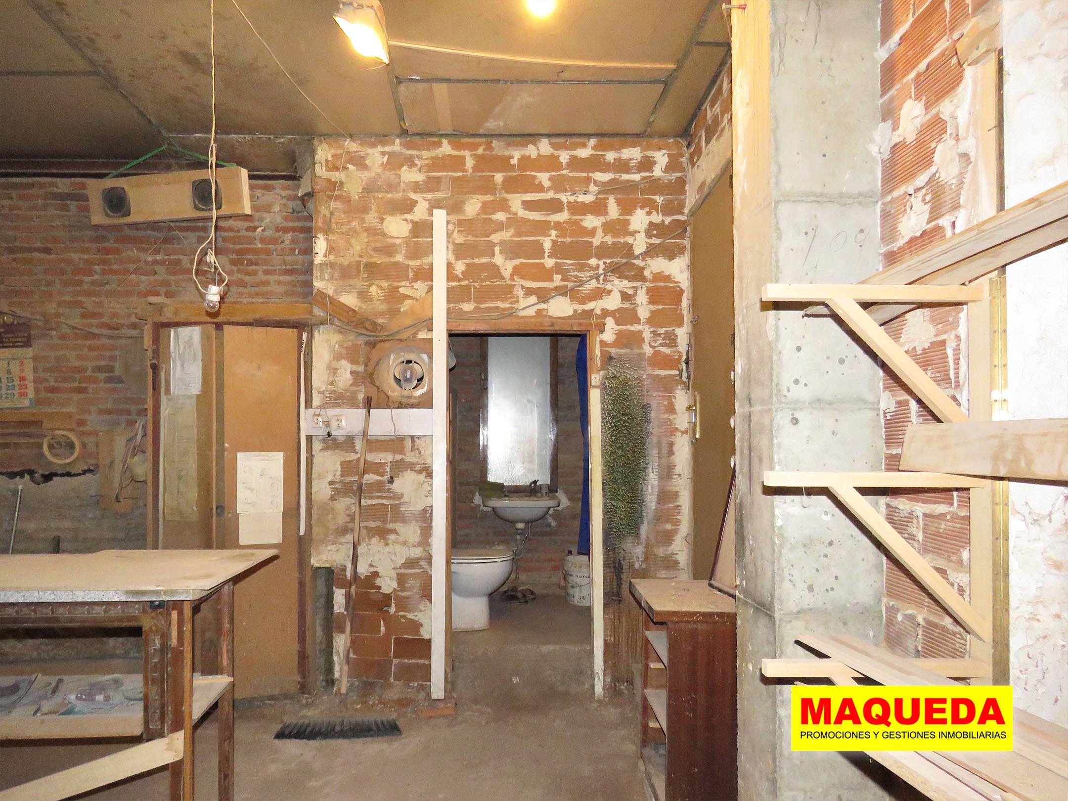Interior del local en venta en Alcorcón con puerta de baño al fondo