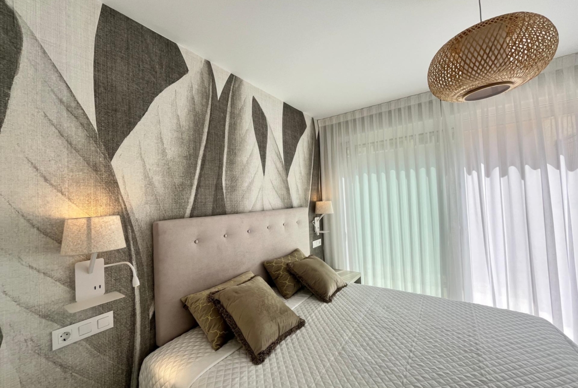 Hotel room with two twin beds, beige headboard, and geometric wallpaper under warm bedside lighting.
