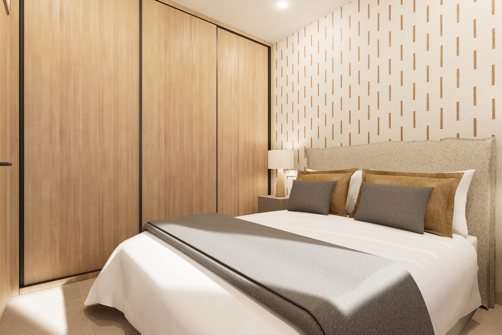 A sunlit modern bedroom with a large wooden wardrobe along the left wall and a cushioned bed against a patterned wall on the right.