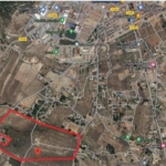 Satellite map highlighting a land parcel outlined in red with a pin marking its location in the southern area.