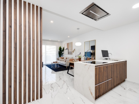 Open-concept living area with a marble floor, wood slat divider on the left, and a marble-and-wood kitchen island in the foreground.