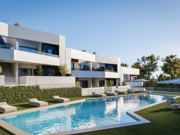 Modern white apartment complex with balconies around a rectangular pool, sun loungers on the lawn, and blue sky above.