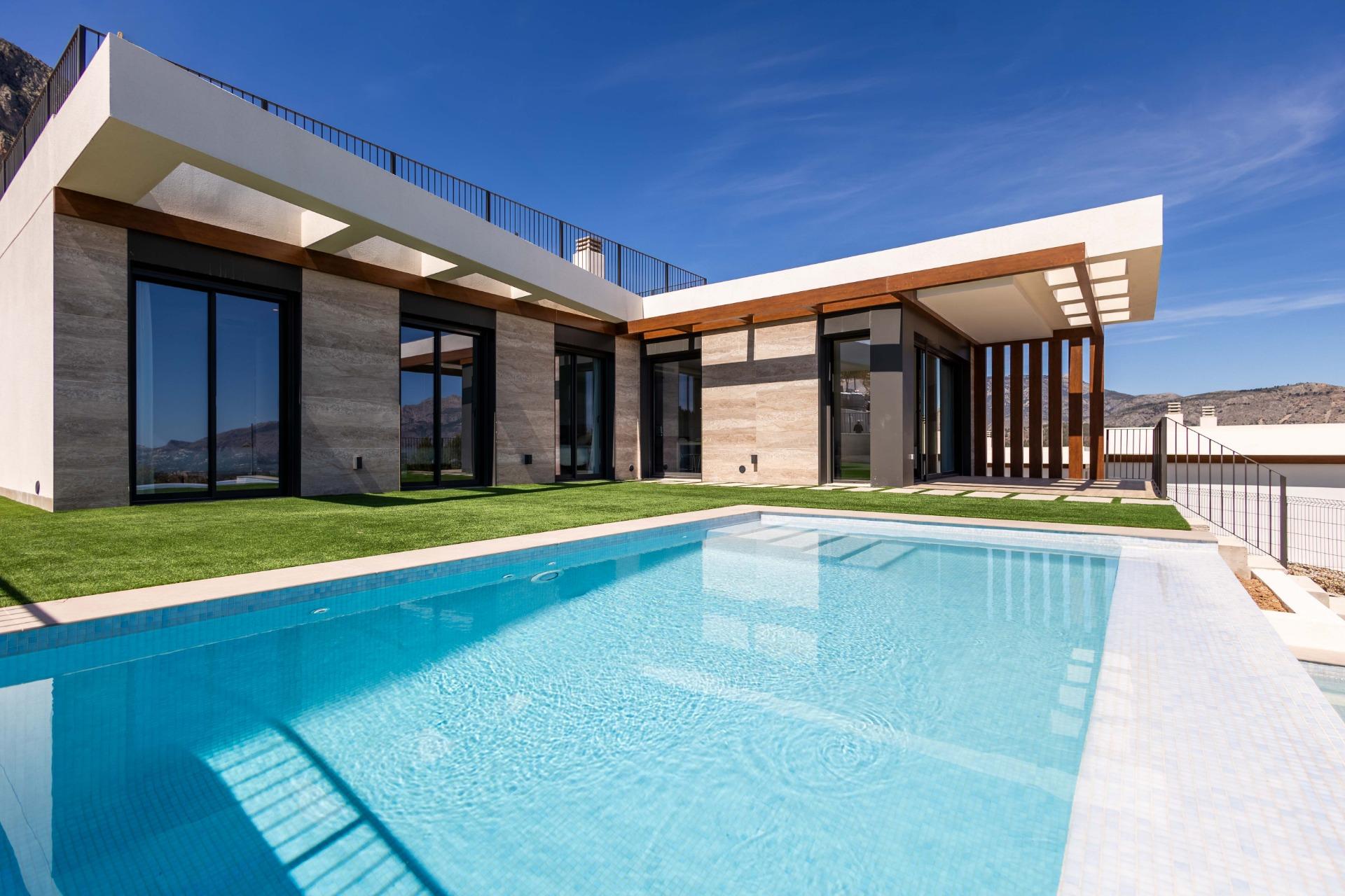 Modern villa with large glass doors, wooden beams, and a rectangular blue-tiled pool in the yard. Suitable for a luxury home exterior image.