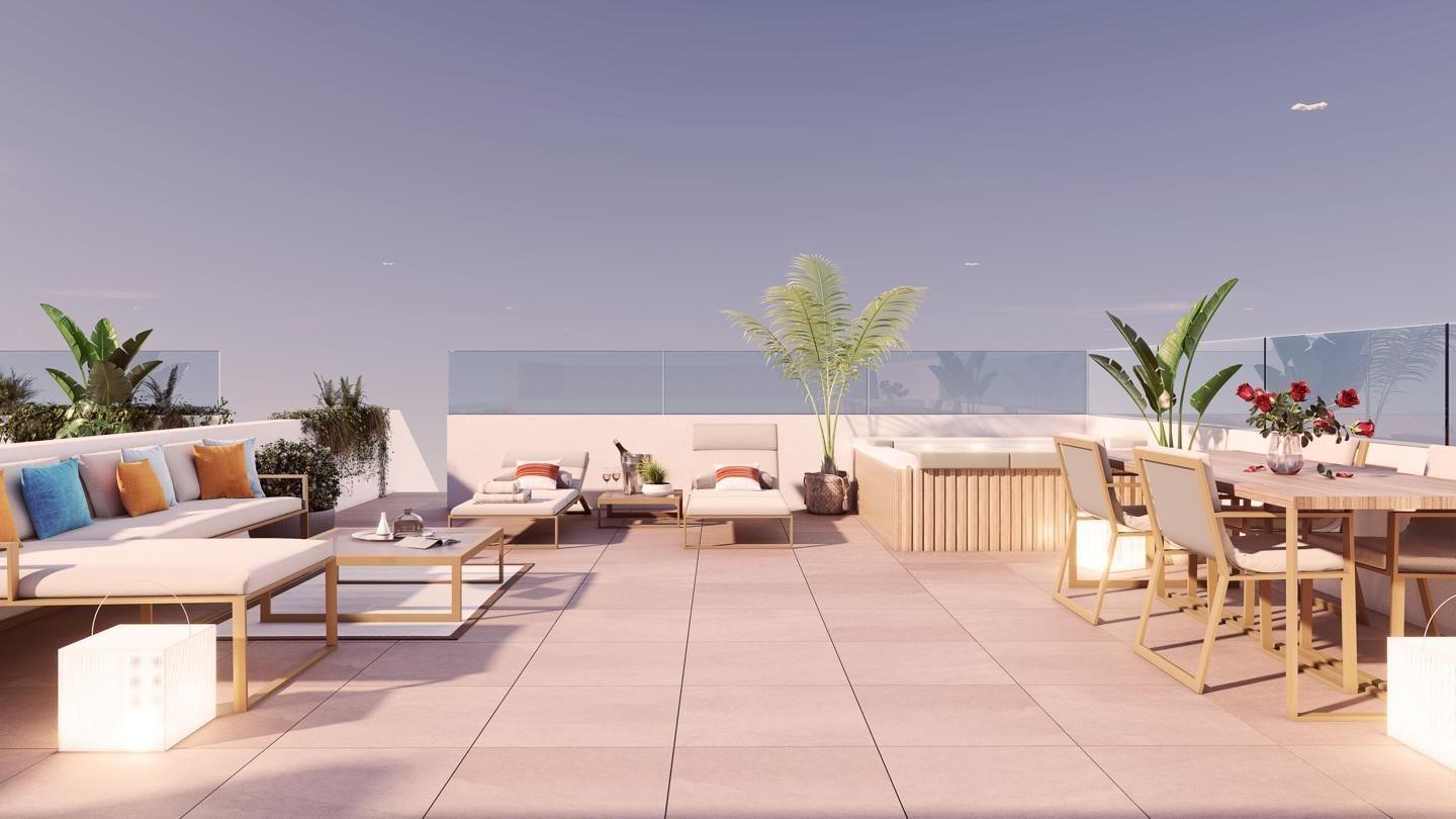 Rooftop terrace with white-and-beige outdoor furniture, potted plants, and a glass railing under a clear sky.