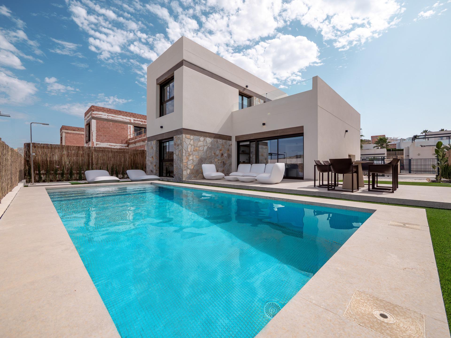 Modern two-story house with a rectangular pool and outdoor seating in a sunny backyard.