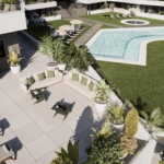 Aerial view of a modern resort pool area with a rectangular pool, circular hot tub, loungers under umbrellas, and surrounding greenery.