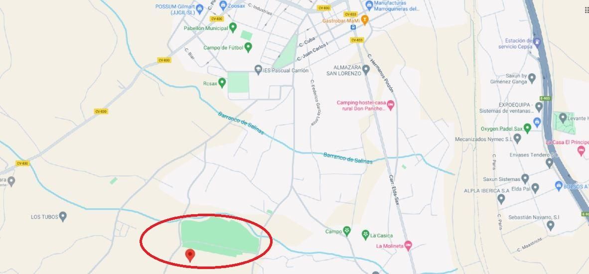 Map highlighting a green rectangular park along a curved blue river, circled in red with a nearby pin
