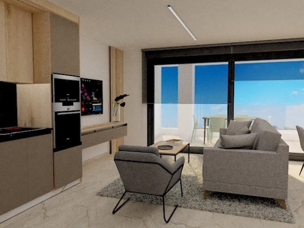 Open-plan living area with a beige kitchen, gray seating, and a balcony with an ocean view through large glass doors.