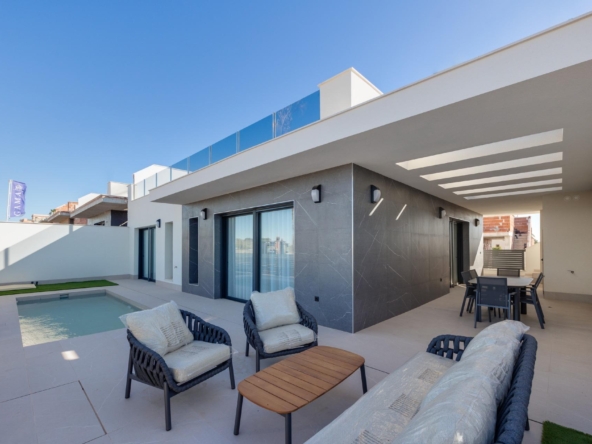 Modern backyard patio with a rectangular pool, white walls, and outdoor seating under a covered area on a sunny day calm and inviting.