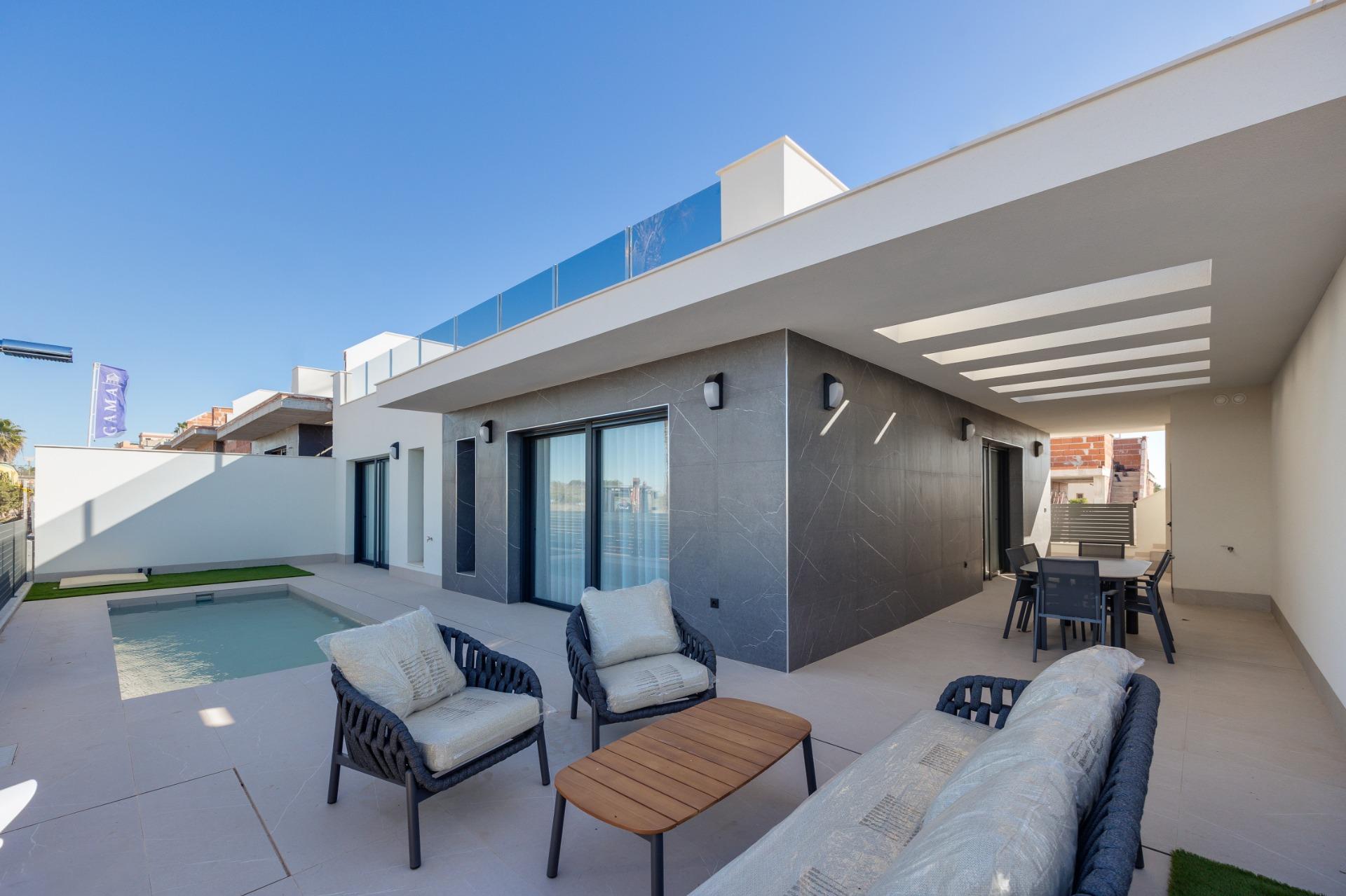Modern backyard patio with a rectangular pool, white walls, and outdoor seating under a covered area on a sunny day calm and inviting.