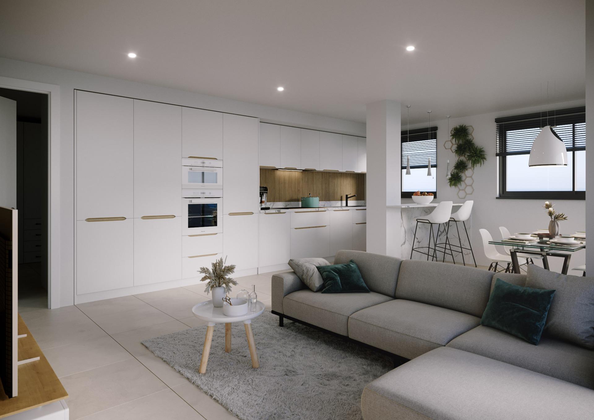 Open-plan living space with white handleless kitchen cabinets, marble island, and a gray sectional sofa under bright ceiling lights.