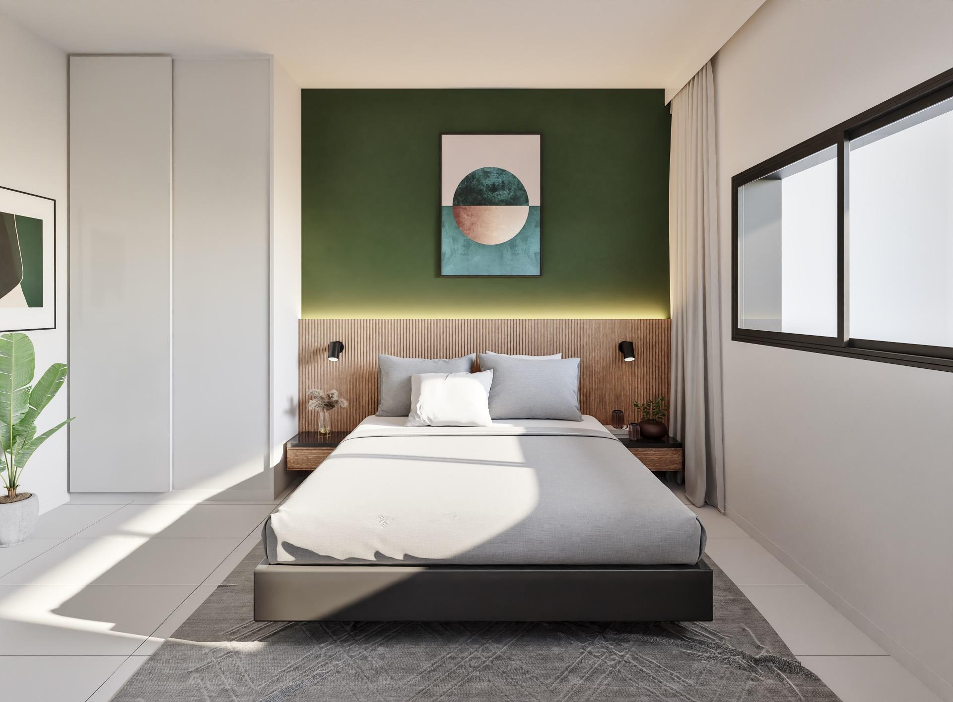 Modern bedroom with a green accent wall, framed geometric art above the bed, and a low platform bed with neutral bedding.
