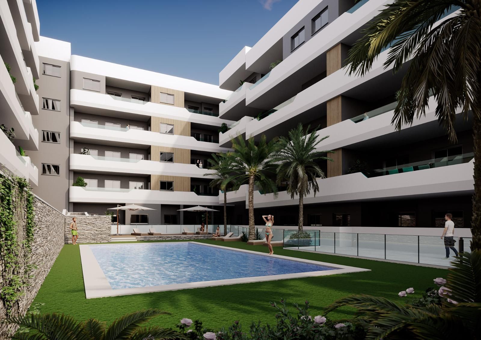 Modern white apartment building surrounding a courtyard pool with palm trees and lounge chairs by the water's edge.