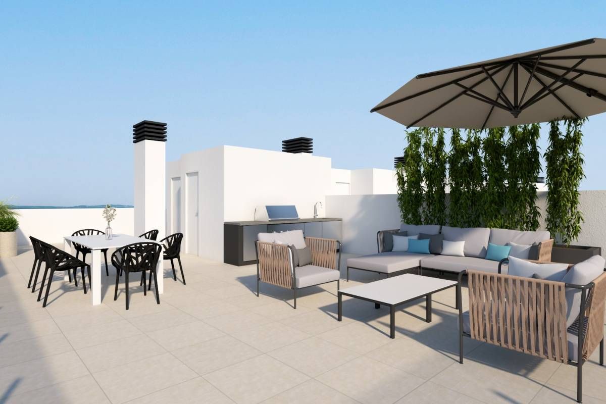 Rooftop patio with white walls, a rectangular dining table and black chairs, and a wicker sectional under a large umbrella.