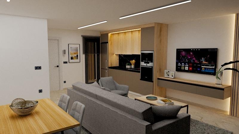 Open-plan living space with gray sofa, armchairs, and a wall-mounted TV in a modern kitchen-dining area.