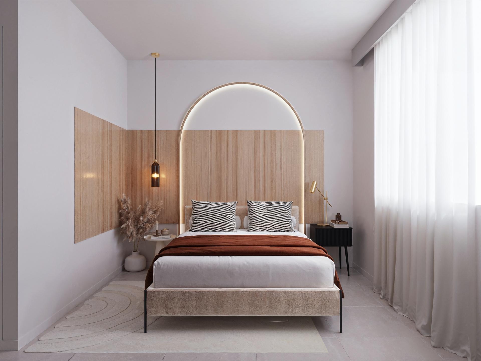 Minimalist hotel bedroom with a low upholstered bed, wooden headboard, and a circular backlit arch mirror orbiting above the bed.
