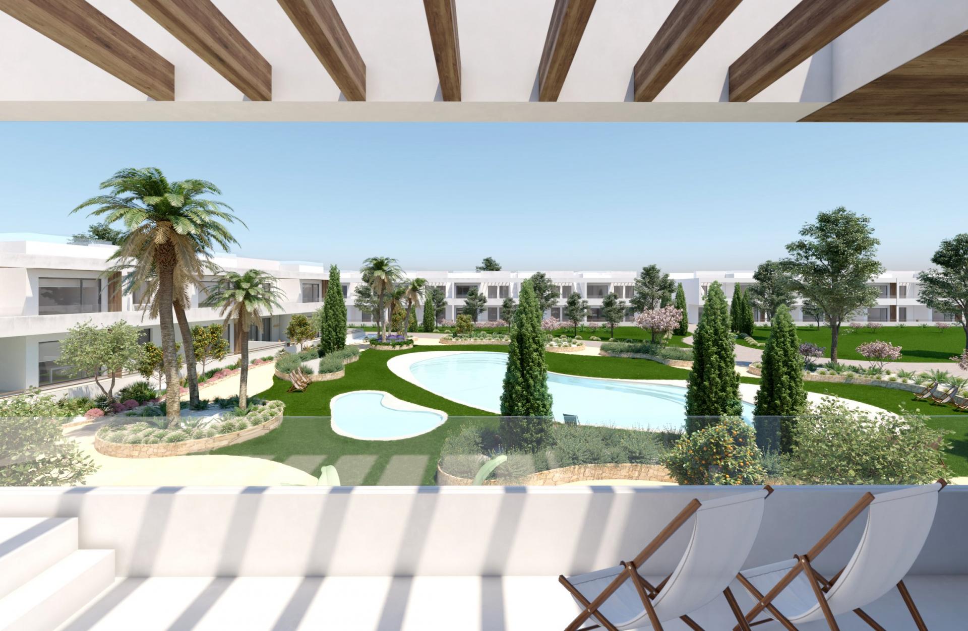 Modern resort courtyard with white low-rise buildings, palm trees, and a winding pool seen from a shaded terrace with wooden beams.