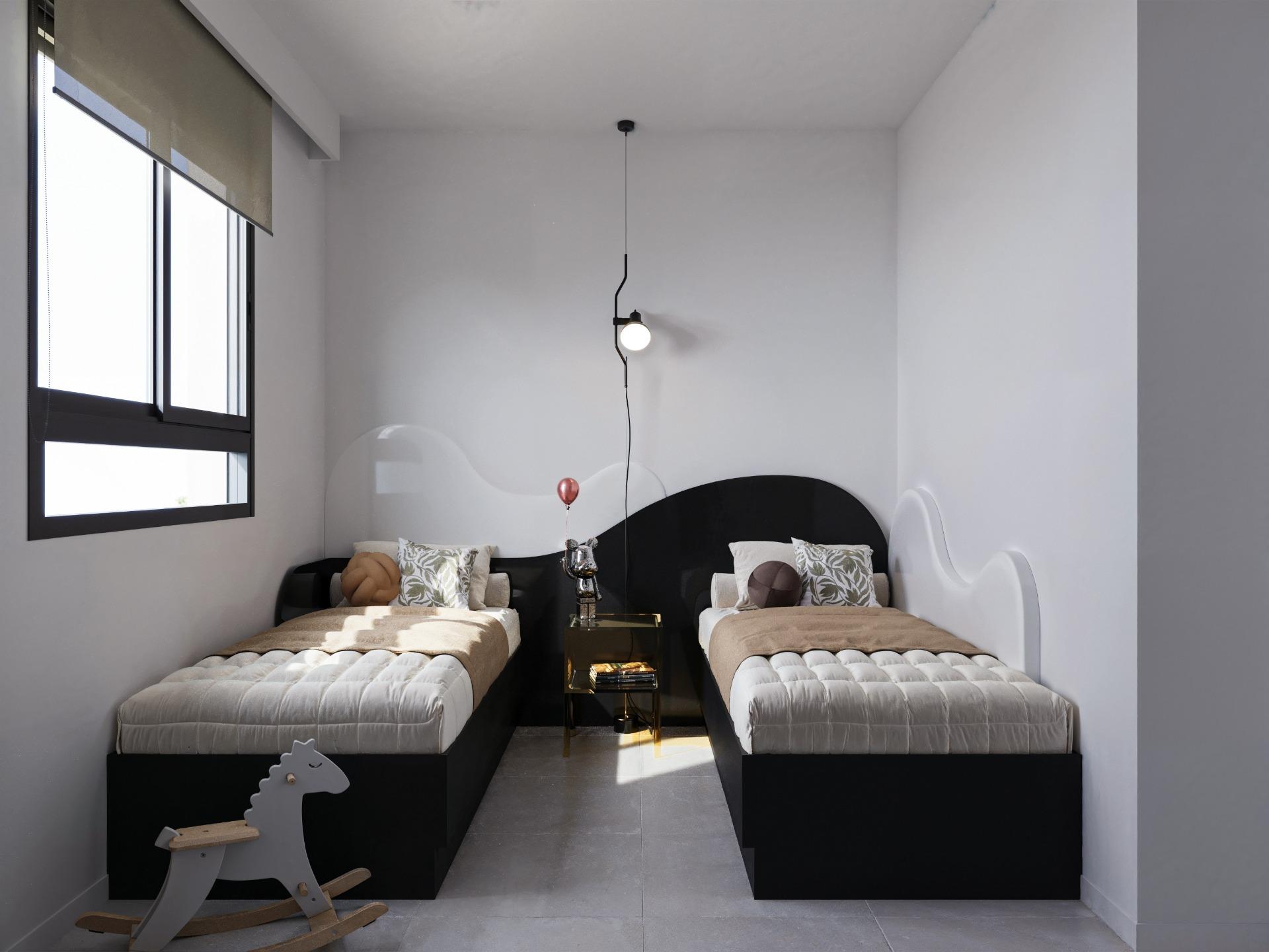 Two twin beds with black frames and beige quilts face a small gold nightstand, in a minimalist gray bedroom.