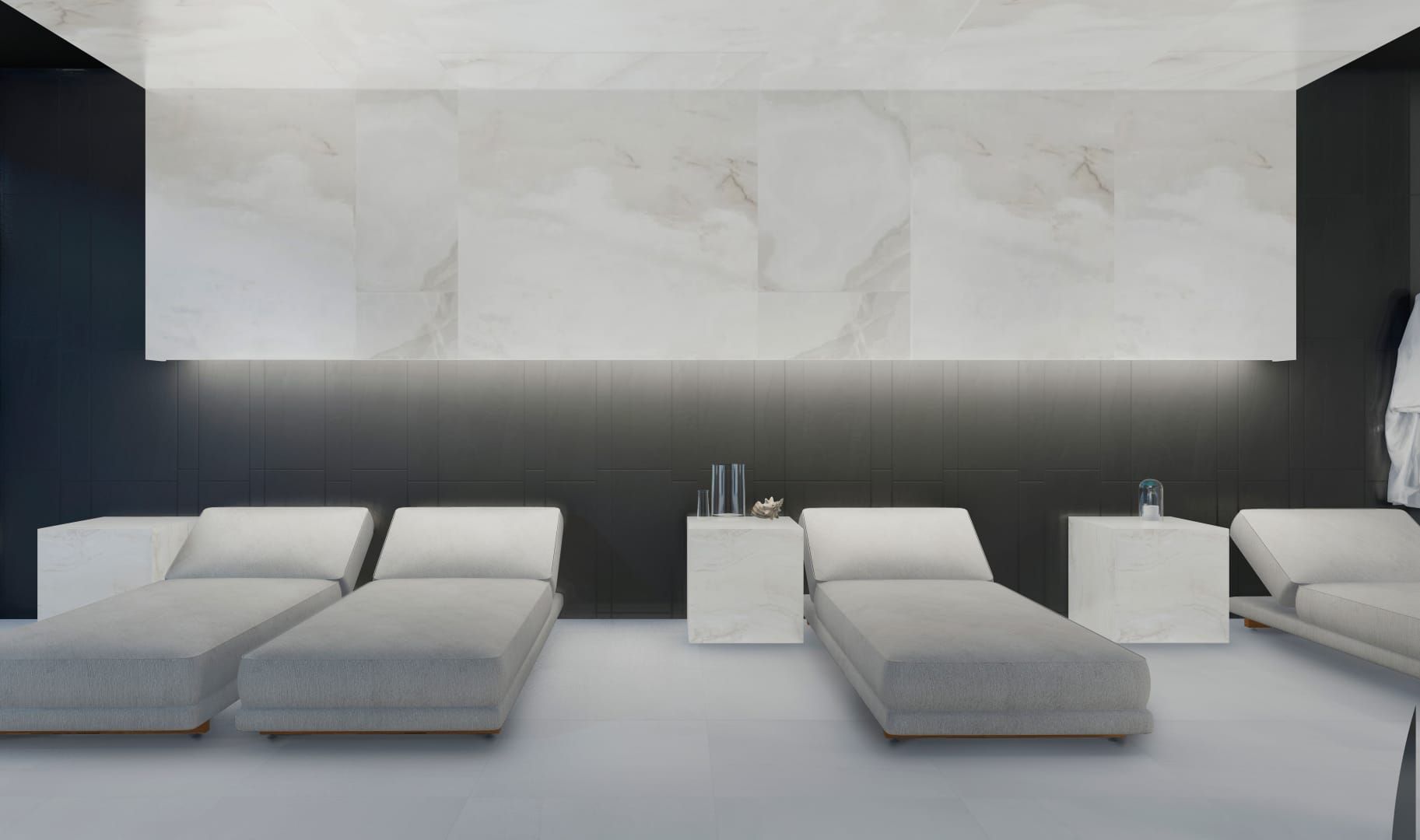 Modern spa lounge with white marble loungers and matching side tables along a dark paneled wall.