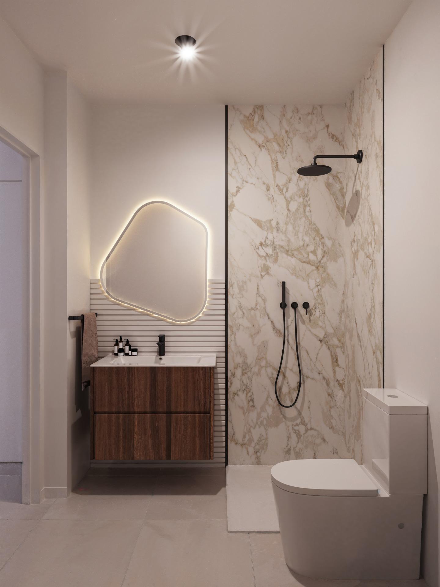 Modern bathroom with a marble-topped shower wall, black matte rain shower head, and wall-mounted faucet; a wooden vanity with a glowing irregular mirror above and a white toilet nearby.