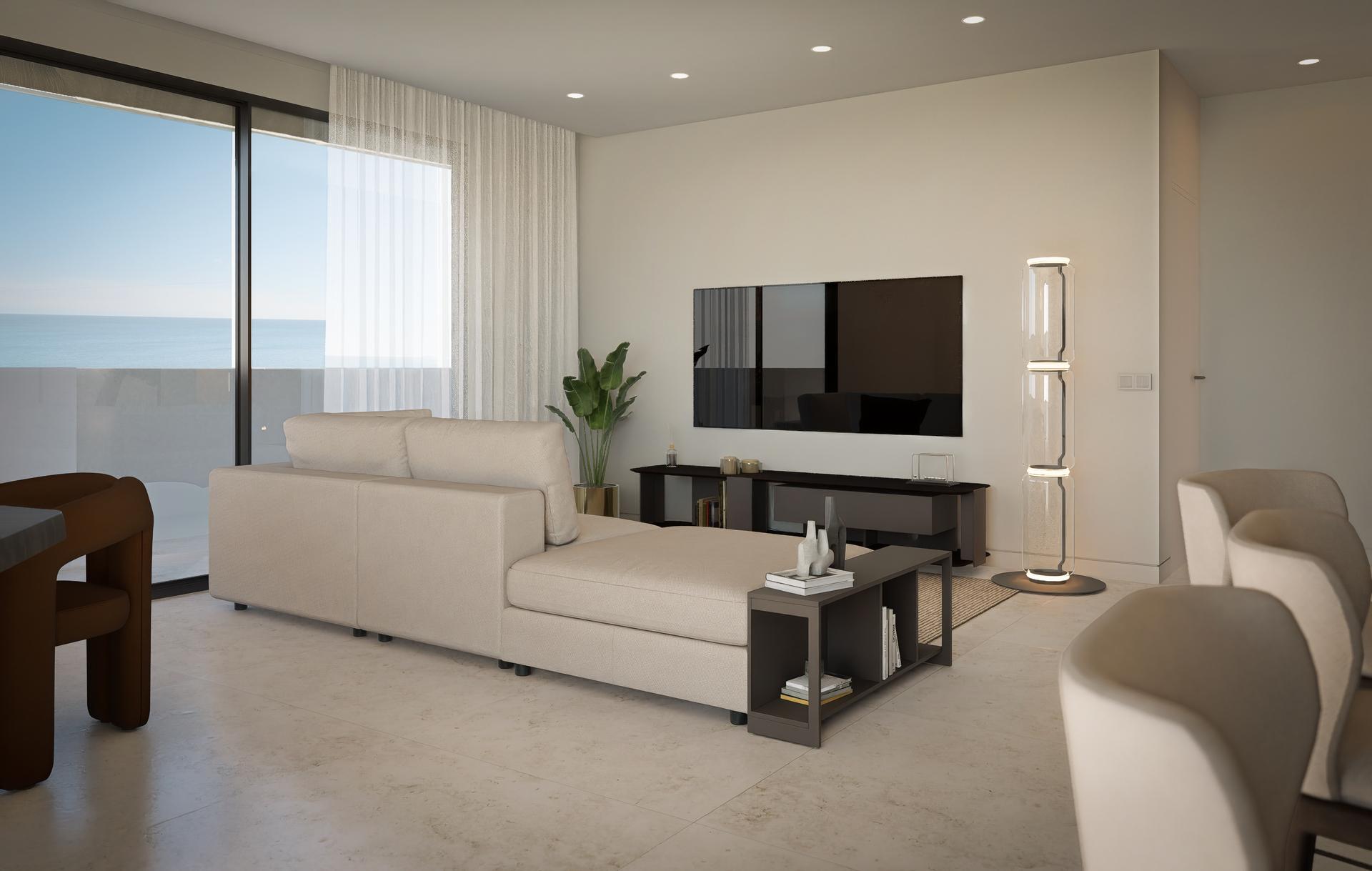 Modern living room with a beige sectional sofa facing a flat-screen TV, a low black media console, and a floor-to-ceiling window showing the ocean outside.